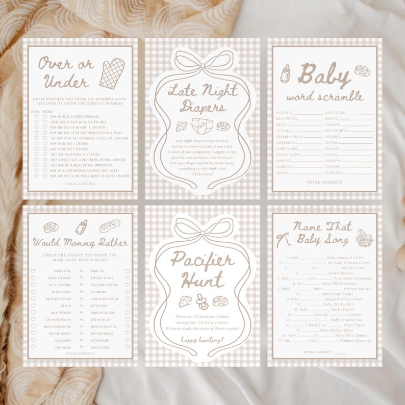 May include: Six beige baby shower game cards with brown text and illustrations. Games include "Over or Under", "Late Night Diapers", "Baby Word Scramble", "Would Mommy Rather", "Pacifier Hunt", and "Name That Baby Song".