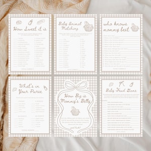 May include: Set of six beige baby shower games with brown text. Games include "How Sweet It Is," "Baby Animal Matching," "Who Knows Mommy Best," "What's in Your Purse," "How Big is Mommy's Belly," and "Baby Feud Game."