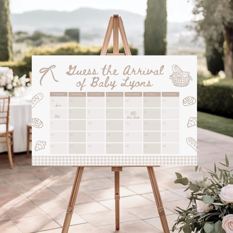 May include: A light beige baby shower calendar sign on a wooden easel. The sign reads "Guess the Arrival of Baby Lyons" with a calendar grid and bread illustrations. The calendar is decorated with a bow and a basket of bread.