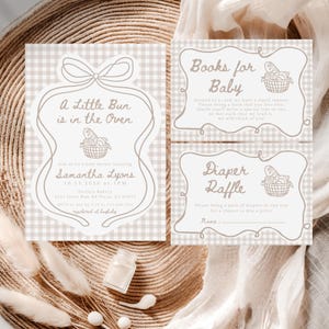 May include: Baby shower invitations and inserts with a tan and white gingham pattern. The main invitation reads "A Little Bun is in the Oven" with event details. Additional cards request books and a diaper raffle.