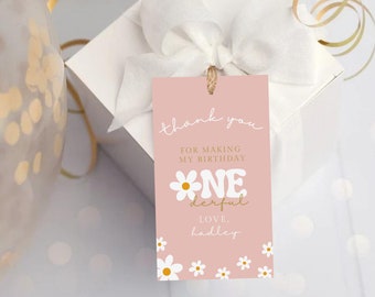 May include: Pink thank you tag with white daisies and gold lettering. The tag says "Thank you for making my birthday one-derful. Love, Hadley."