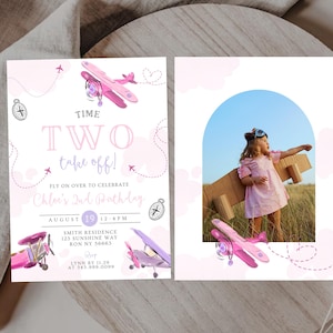 May include: A two-sided invitation with a pink airplane theme. The left side has text that reads "TIME TWO take off!" and details for a birthday party. The right side features a photo of a child with cardboard wings.