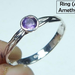 May include: A silver ring with a round, purple amethyst gemstone. The band has a twisted design. The text "Ring (A) Amethyst" is in the upper right corner.