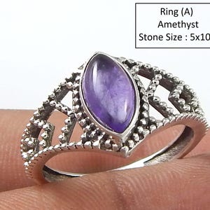 May include: A silver ring with a purple amethyst stone set in a delicate, intricate design. The stone is oval-shaped and measures 5x10mm. Ring (A) Amethyst Stone Size: 5x10mm