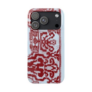 May include: A smartphone case with a red and white patterned design. The case has a light blue border and a black camera module with three lenses. The pattern is a repeating geometric design.