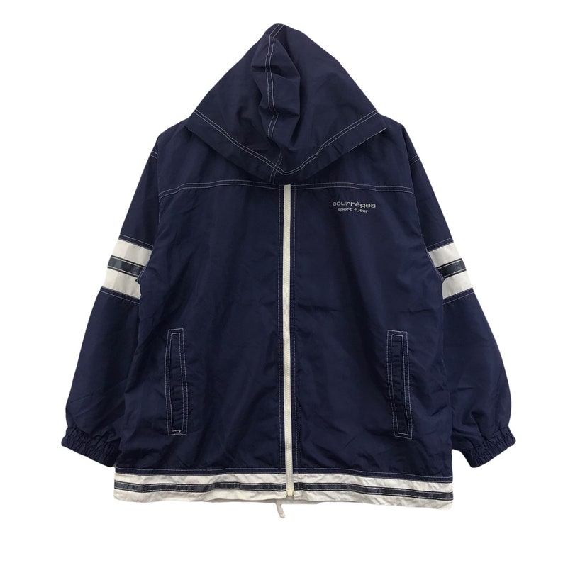 May include: Navy blue hooded jacket with white accents and a full-length zipper. The jacket features white stripes on the sleeves and along the bottom hem. The text "courr&egrave;ges sport futur" is printed on the chest.