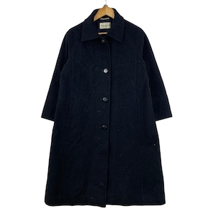 May include: A black wool coat with a collared neckline and button-down closure. The coat has long sleeves and a knee-length hem. The coat is hanging on a wooden hanger.