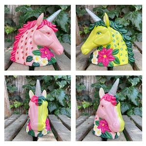May include: Four ceramic unicorn figurines with painted floral and strawberry designs. Each unicorn has a different colour scheme and floral pattern.