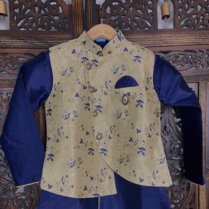 May include: A blue and gold kurta with a floral pattern. The kurta has a mandarin collar and a button closure. It is paired with a matching waistcoat.