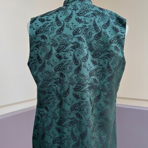 May include: A sleeveless vest with a dark green background and a black paisley pattern.