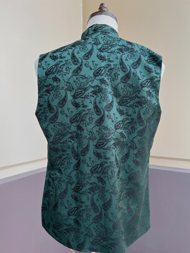 May include: A sleeveless vest with a dark green background and a black paisley pattern.
