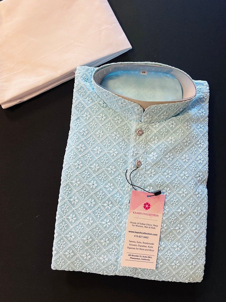 Pu&ograve; includere: Una kurta ricamata di colore azzurro chiaro con colletto bianco e chiusura con bottone. La kurta &egrave; realizzata in un tessuto morbido e leggero, perfetta per il clima caldo. L'etichetta sulla kurta riporta "Kaash Collection" e include il sito web e il numero di telefono dell'azienda.