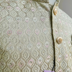 May include: A light green men's jacket with a gold button closure and a diamond pattern. The jacket has a tag that reads "KAASH COLLECTION".