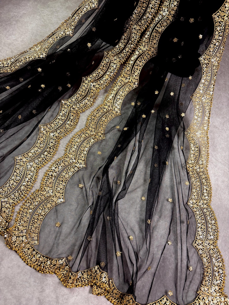 May include: Black sheer fabric with a gold embroidered border. The border features a scalloped design with small gold beads and sequins.