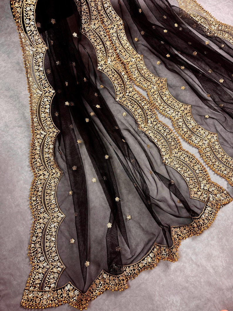 May include: Black sheer fabric with gold embroidered trim. The trim features a scalloped design with small beads.