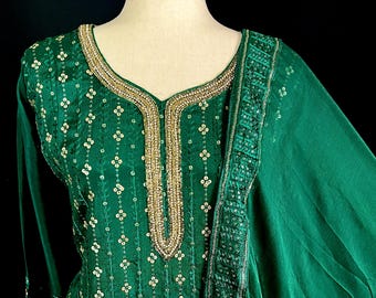 Könnte beinhalten: Eine grüne bestickte Kurta mit goldener Halslinie und passendem Dupatta. Die Kurta hat ein Blumenmuster und ist mit Pailletten verziert.