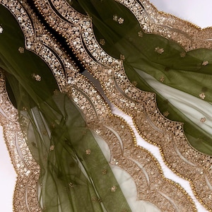 May include: Olive green sheer fabric with ornate gold sequin and bead embellishments. The fabric features a scalloped edge design with intricate detailing. The gold accents create a luxurious and elegant look, suitable for formal wear or decorative purposes.