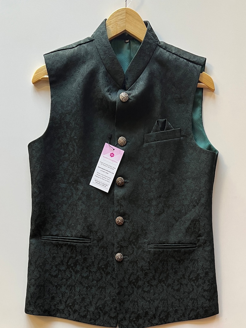 Puede incluir: Un chaleco verde oscuro sin mangas con cuello mandar&iacute;n y cinco botones plateados. El chaleco tiene un sutil estampado floral y dos bolsillos.