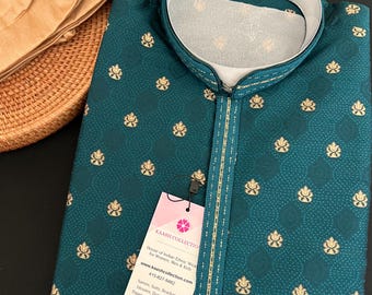 May include: A teal blue kurta with gold embroidery and a gold trim. The kurta has a mandarin collar and a button closure. The tag on the kurta reads "Kaash Collection, House of Indian Ethnic Wear for Women, Men & Kids, www.kaashcollection.com, 415-827-9482, Sarves, Suits, Readymade Blouses, Dupattas, Kurta Pajamas for Mens and Boys, 405 Boulder Ct. Suite 200-J, Pasadena, California."