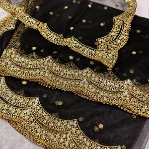 May include: Black sheer fabric with a gold embroidered border. The border features a scalloped design with sequins and beads.