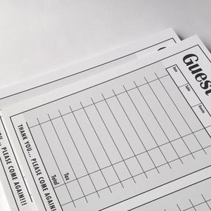 Pu&ograve; includere: Un modulo di controllo ospiti bianco vuoto con le parole "Guest Check" stampate in nero nella parte superiore. Il modulo ha colonne per la data, il tavolo, gli ospiti, il server, l'imposta e il totale. La parte inferiore del modulo dice "Thank you... Please come again!"