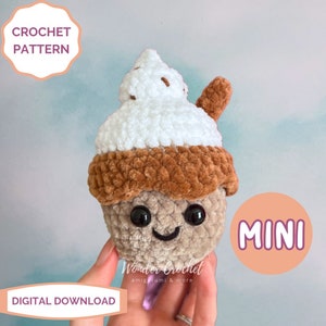 May include: Crochet pattern for a mini amigurumi ice cream cone with a brown base, white whipped cream topping, and a brown chocolate drizzle. The ice cream cone has a cute face with black eyes and a smiling mouth. The pattern is available for digital download. "MINI" is written in white text on a peach background.