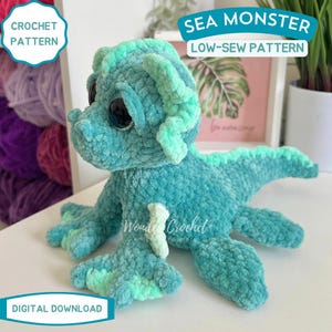 Peut inclure: Un jouet de monstre marin crochet&eacute; turquoise avec de grands yeux noirs et des accents vert clair. La cr&eacute;ature en peluche a un motif &agrave; faible couture et est &eacute;tiquet&eacute;e "Sea Monster" et "Crochet Pattern". Les mots "Digital Download" sont &eacute;galement visibles.