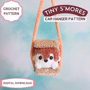 May include: A crochet pattern for a tiny s'mores car hanger. The s'mores is made of brown, orange, and white yarn and has a happy face. The pattern is available as a digital download.