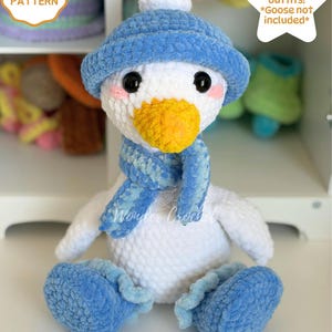 May include: A white crochet goose plush toy wearing a blue hat with a white pom-pom, a blue scarf, and blue shoes. The goose has black eyes and a yellow beak. Text on the image reads: CROCHET PATTERN, 8 Seasonal outfits! *Goose not included*, DIGITAL DOWNLOAD.