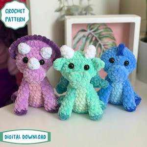 May include: Three plush dinosaur toys made of soft, fuzzy yarn. The left is purple with white horns, the center is mint green with white horns, and the right is blue. Each has black plastic eyes. Text reads: CROCHET PATTERN DIGITAL DOWNLOAD.