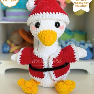 May include: A white crocheted goose plush wearing a red and white Santa hat and a red jacket with a black belt. The goose has orange feet and a yellow beak. Text on the image reads: CROCHET PATTERN, 8 Seasonal outfits! *Goose not included*, DIGITAL DOWNLOAD.