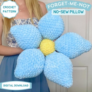May include: A large, handmade, flower-shaped pillow with light blue petals and a yellow center. The pillow is made of a soft, textured material. Text on the image reads "FORGET-ME-NOT NO-SEW PILLOW" and "CROCHET PATTERN".