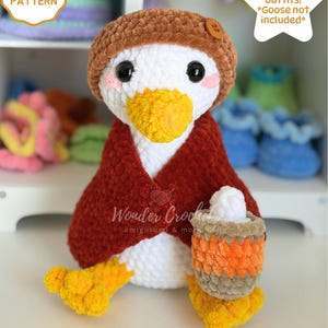 May include: A white crocheted goose amigurumi wearing a brown hat with a button and a dark red cape, holding a small striped basket. Text reads: CROCHET PATTERN, 8 Seasonal outfits! *Goose not included*, Wonder Crochet amigurumi & more, DIGITAL DOWNLOAD.