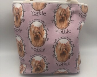 May include: A pink tote bag with a repeating pattern of Yorkshire Terriers in a frame with the text "Yorkie" and "Life is better with a Yorkie".