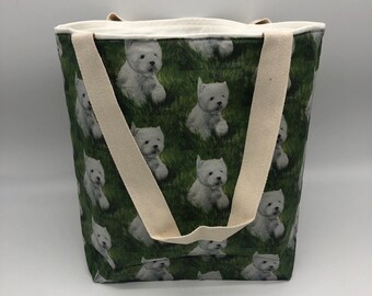 May include: A white canvas tote bag with a green background and a pattern of white West Highland White Terriers. The bag has two cream-colored straps.