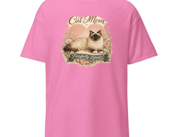 May include: A bright pink short-sleeve t-shirt featuring a graphic print of a Siamese cat lying down inside a heart shape surrounded by flowers. The text Cat Mom is printed above the cat, and the text Purrfectly Loved is printed on a banner below.