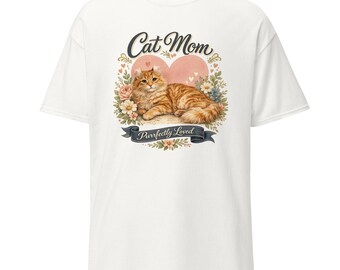 May include: A white short-sleeve t-shirt featuring a graphic of a ginger cat lying in front of a pink heart, surrounded by flowers. The text "Cat Mom" appears above the cat, and a banner below reads "Purrfectly Loved" in dark blue lettering.