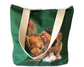 May include: A green canvas tote bag with a white cotton handle features a printed image of a brown and white hen with chicks.