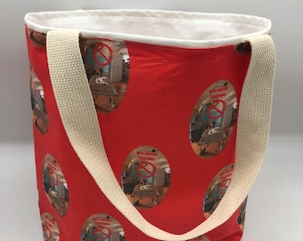 May include: Red canvas tote bag with white straps. The bag has a repeating pattern of a white circle with a red slash through it and the text "No More Testing".