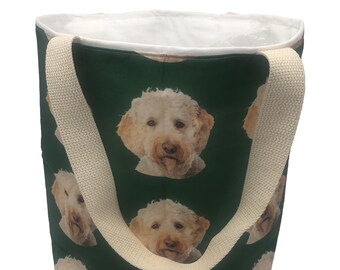 May include: A green canvas tote bag with white straps. The bag features a repeating pattern of a dog's face.