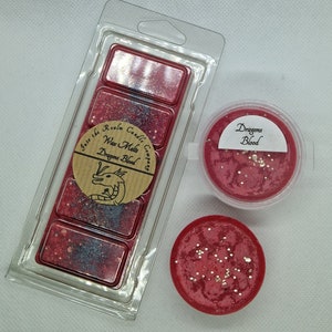 May include: A wax melt set with a red and silver glitter scent called "Dragons Blood" from the Into the Realm Candle Company. The set includes a wax melt clamshell and a single wax melt.