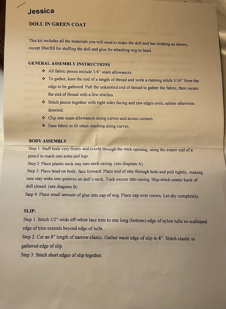 May include: Printed instructions for a doll in a green coat, with assembly steps and general instructions. The text includes details on fabric pieces, stitching, and body assembly, with diagrams referenced. The document is titled "Jessica".
