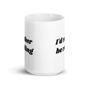 May include: White ceramic coffee mug with black text that reads "I'd rather be rolling".