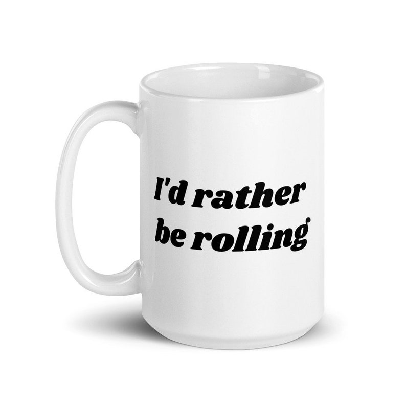 May include: White ceramic mug with black text that reads "I'd rather be rolling".