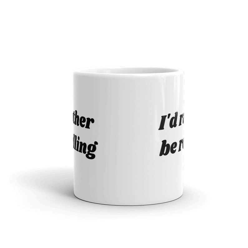 May include: White ceramic mug with black text that reads "I'd rather be reading" on the right side and "other than that I'm calling it a day" on the left side.