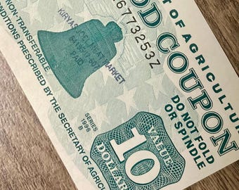 May include: A green and white food coupon from the Department of Agriculture. The coupon has the text "FOOD COUPON" and "VALUE 10 DOLLARS". The coupon also has the text "DO NOT FOLD OR SPINDLE".