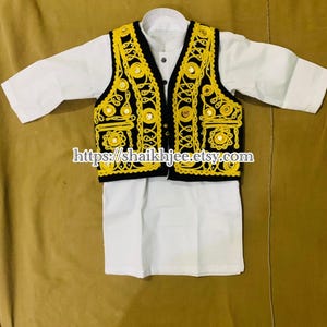 May include: A traditional outfit for children, featuring a white shirt and a black vest with yellow embroidery and mirror accents. The outfit is designed with a classic style, perfect for cultural events.