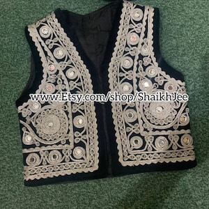 May include: Black vest with intricate silver embroidery and small mirrored accents. The vest features a V-neck design and is embellished with detailed patterns. The Etsy shop URL is visible on the image.