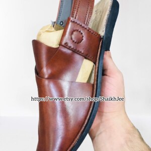 K&ouml;nnte beinhalten: Braune Ledersandale mit Riemen und schwarzer Sohle. Die Sandale hat ein dekoratives Nahtdetail am Riemen. Das Bild enth&auml;lt den Text "https://www.etsy.com/shop/ShaikhJee".