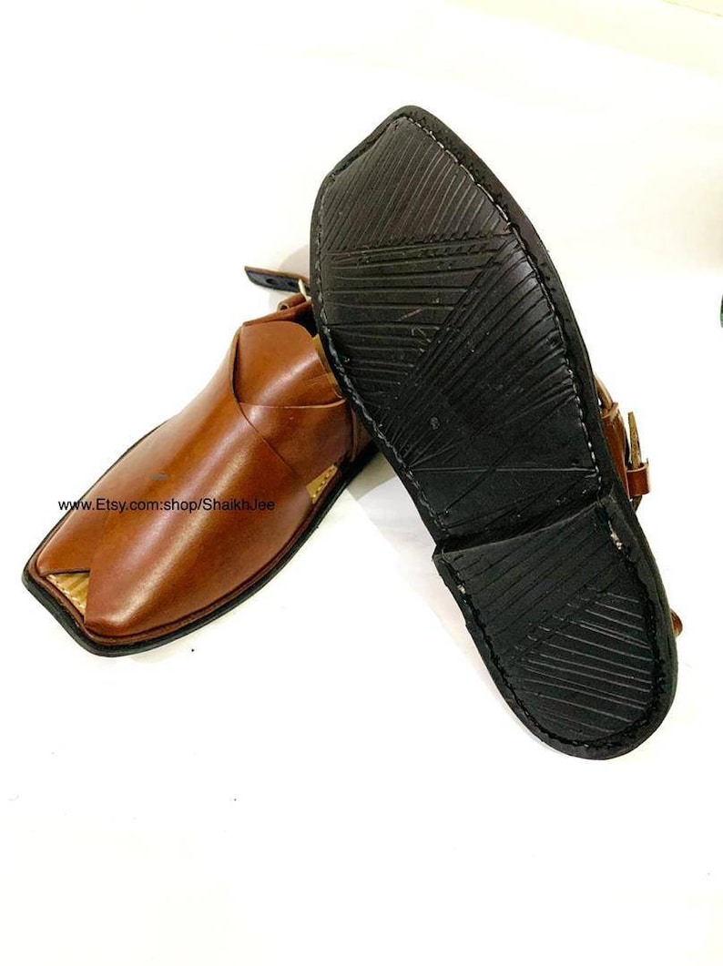 K&ouml;nnte beinhalten: Ein Paar braune Peshawari-Ledersandalen mit quadratischer Zehenpartie und Riemen. Die Sandalen haben eine dunkelbraune Sohle mit strukturiertem Muster. Der Etsy-Shop-Name ist sichtbar.